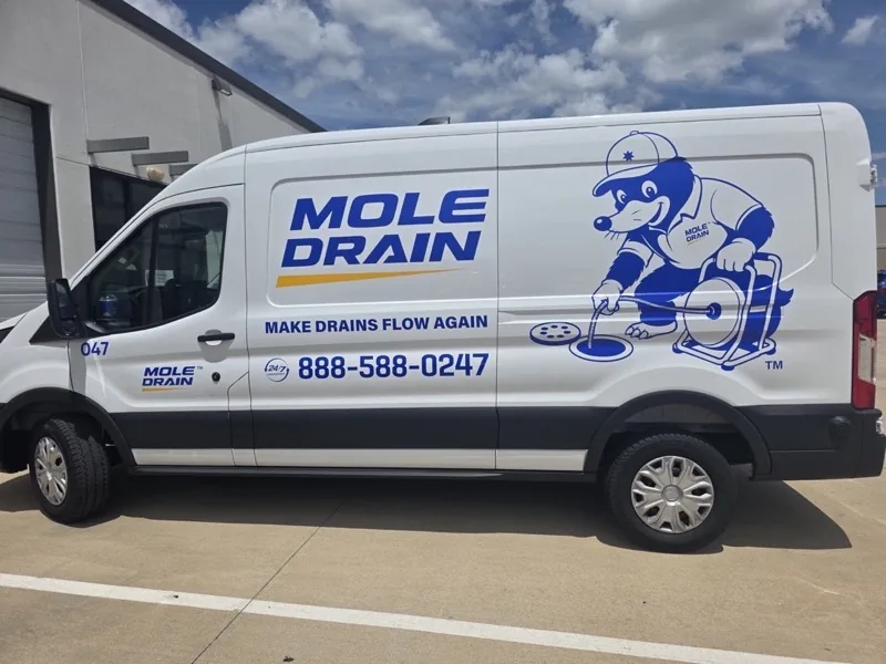 White fleet van with full-color drain company graphics